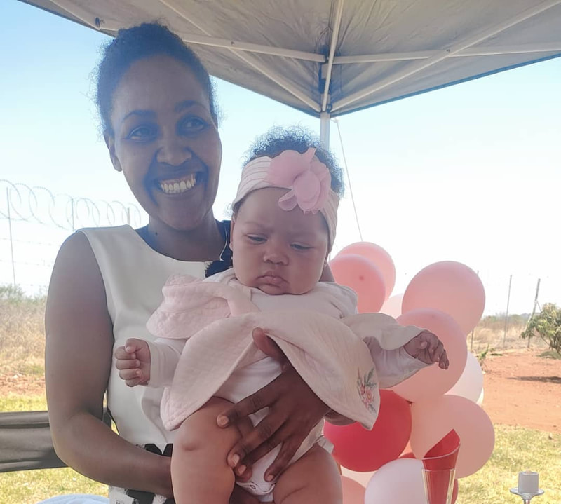 A mother holding her baby at S.M.I.L.E. Village